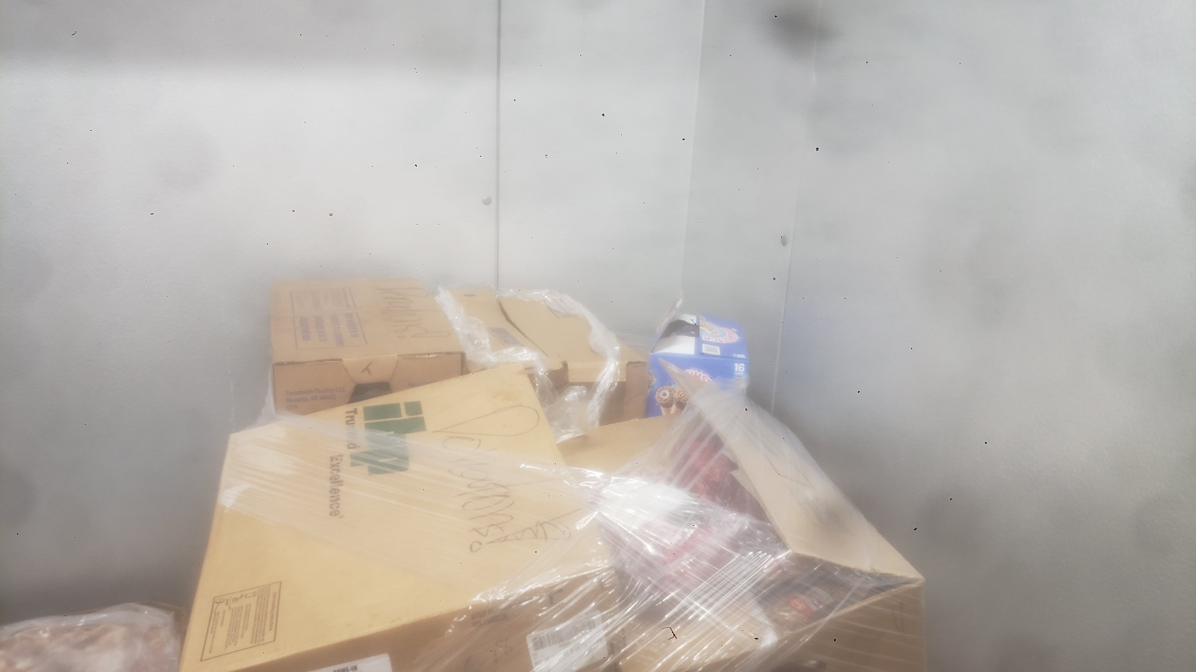 Cardboard boxes wrapped in plastic wrap. Some are labeled as donations